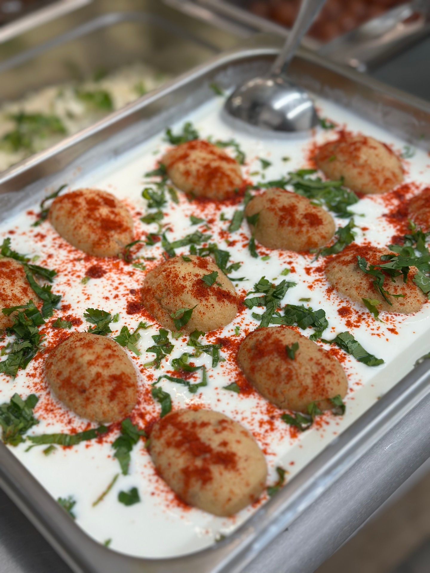 Dahi vada — soft lentil dumplings in chilled yogurt with mint and paprika
