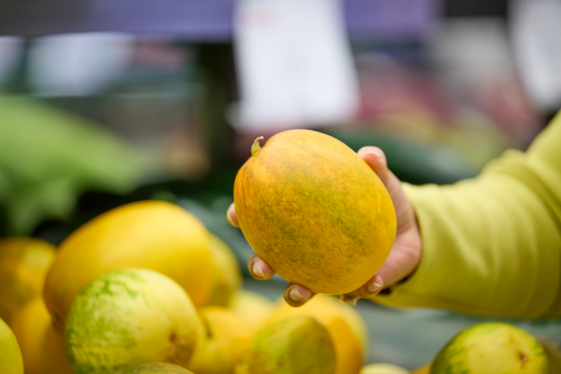 Customer selecting a fresh mango